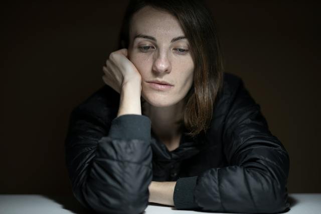 Woman sitting at a table and looking sad