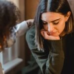 A anxious woman sits in a chair and may need to seek anxiety therapy in Chicago.