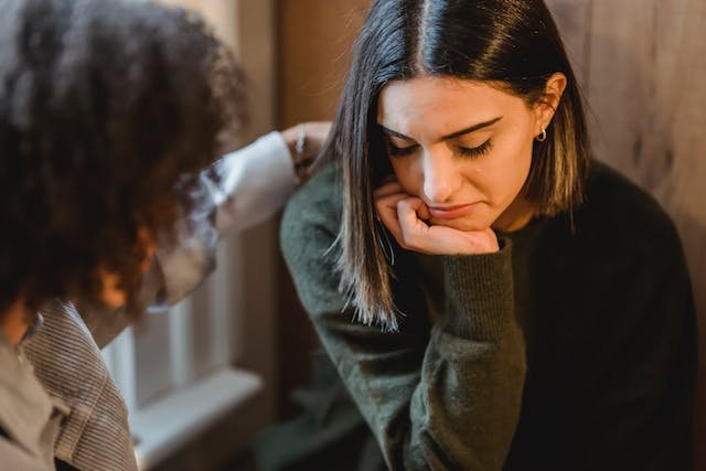 A anxious woman sits in a chair and may need to seek anxiety therapy in Chicago.